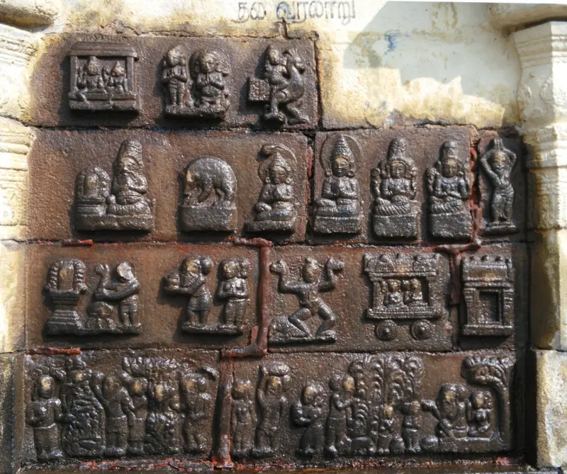 Rows of small stone relief panels showing figures, a bull, a chariot and groups of people.