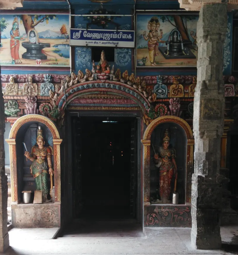 Painted doorway with guardian statues and legend murals above