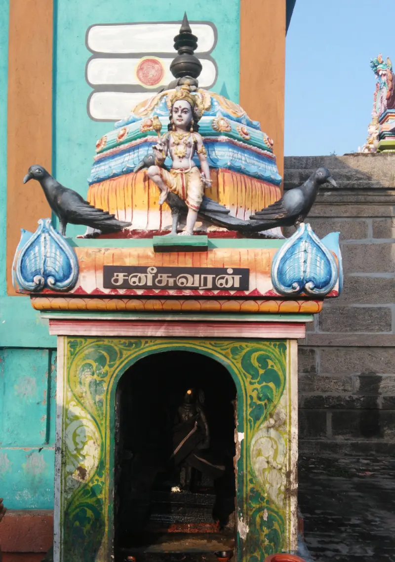A colorful Sani shrine with crows above and dark idol within