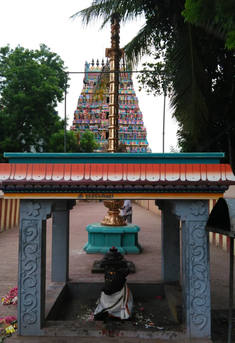 Bull statue and golden pole in front of a colourful tower