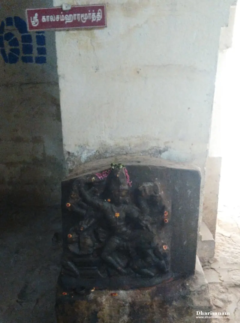 A carved stone relief of a many-armed figure on a block, with a board above reading Sri Kalasamharamurthy