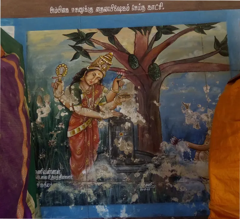 Wall painting of a goddess pouring oil over a lingam beneath a tree, with a Tamil caption above