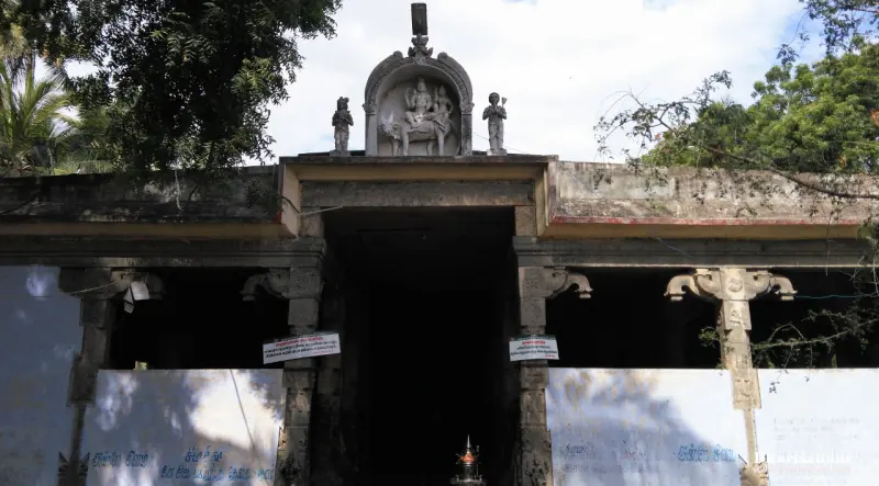 Stone entrance hall with a carved figure group on top, showing a deity seated on a bull