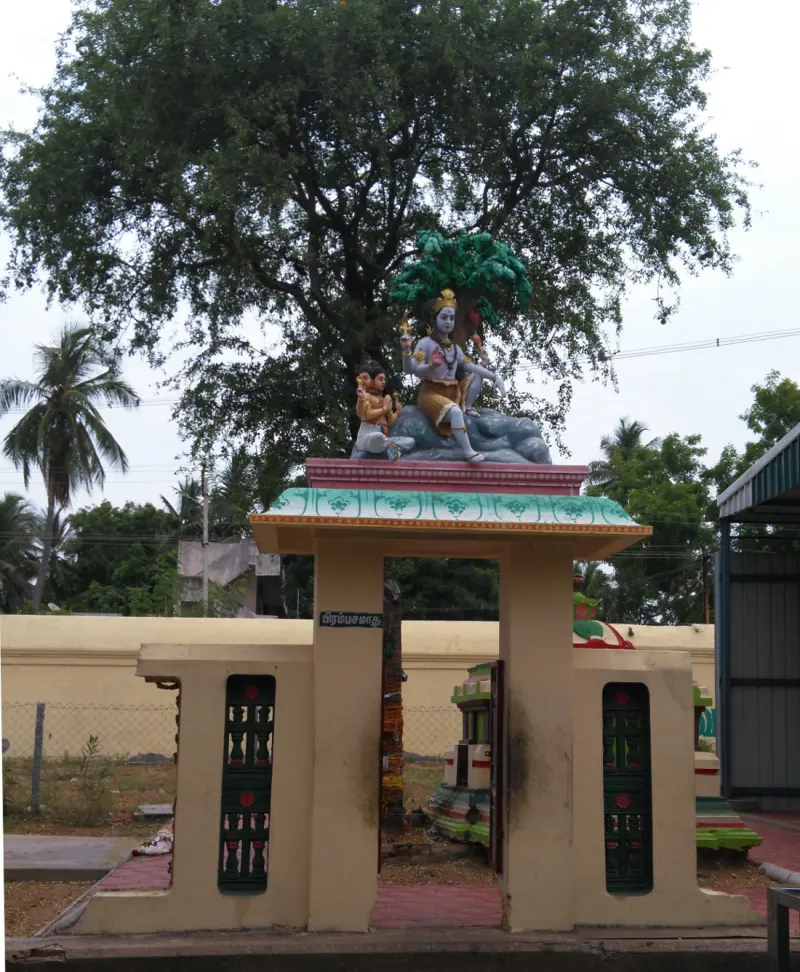 A small gateway with a seated Brahma figure on top, beneath a large tree; the board reads Brahma Samaadhu