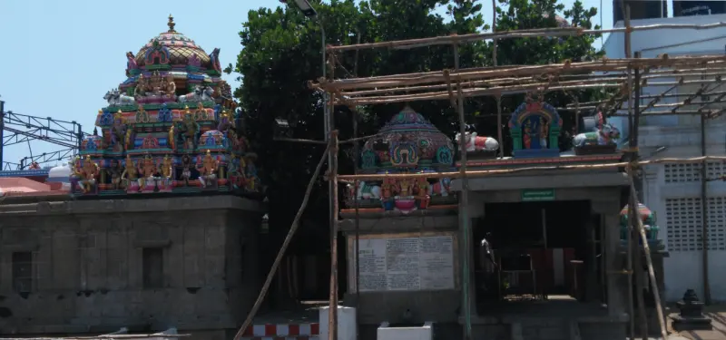 A small painted dome on the left, and a porch with bamboo scaffolding on the right.