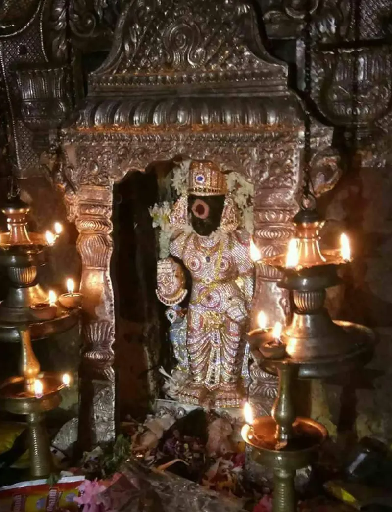 Saneeswarar in the sanctum, lit by oil lamps