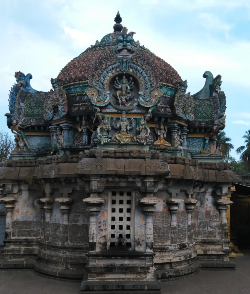 Sanctum with a latticed stone window and a domed roof topped by painted figures
