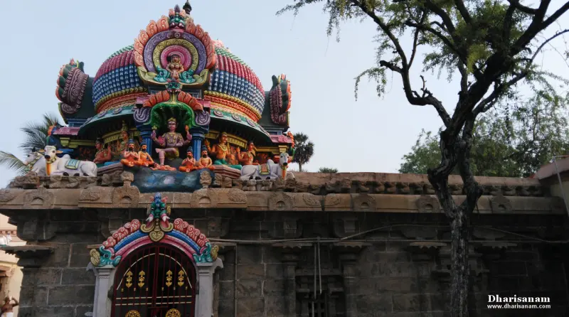 Dome tower with Nandi and devotee sculptures above a gated shrine