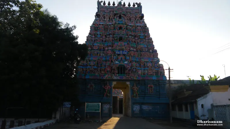 A tall tower covered in painted figures above a blue stone base, with a doorway at its foot.