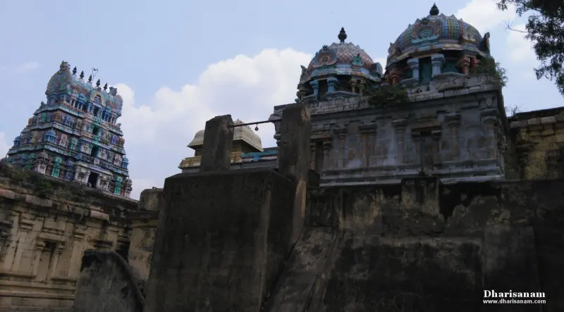 Painted tower and two domes rising above dark stone walls
