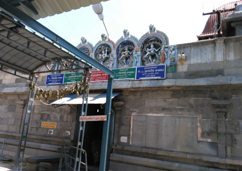Dancing figures on a wall with coloured name boards for the halls, above a dark doorway