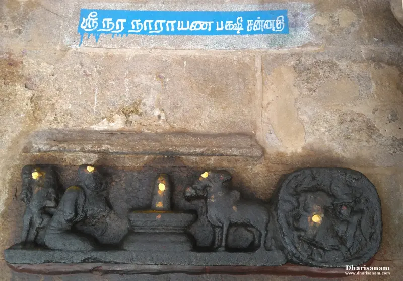 Stone relief of two crane figures, a lingam and a bull, under a Tamil name board