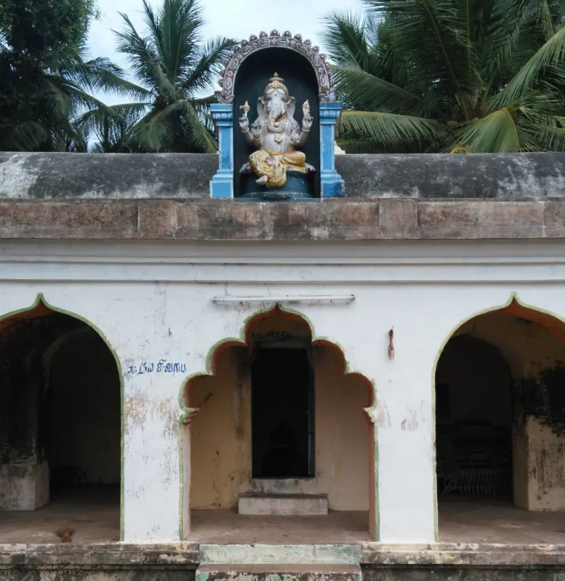 A whitewashed corridor shrine with a small figure of Vinayakar above its centre