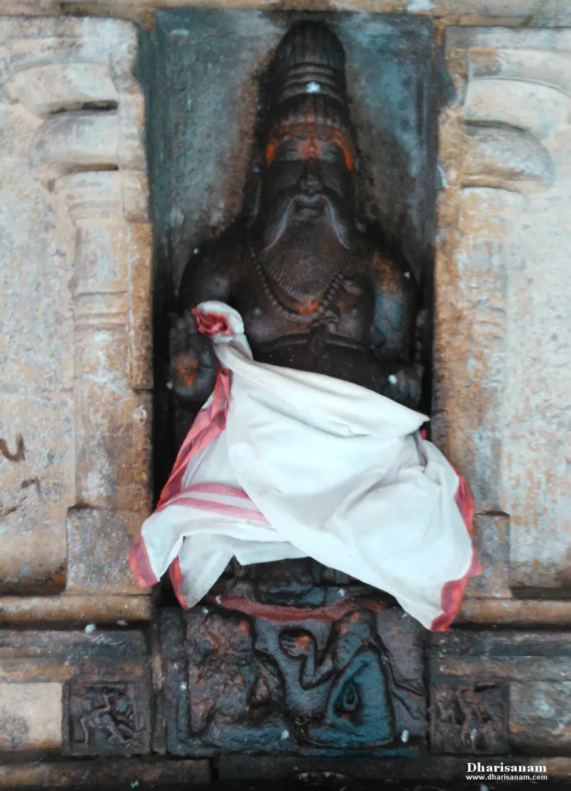 Bearded stone figure in a wall niche, with a white cloth across its lap