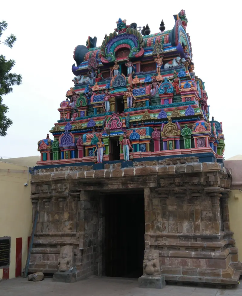 Colourful mini gopuram above a carved stone doorway