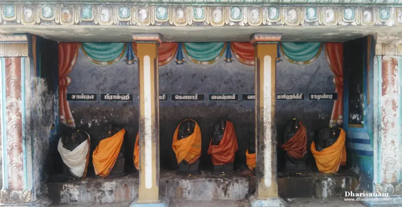 Black stone idols draped in orange cloth, with a Tamil name painted above each one