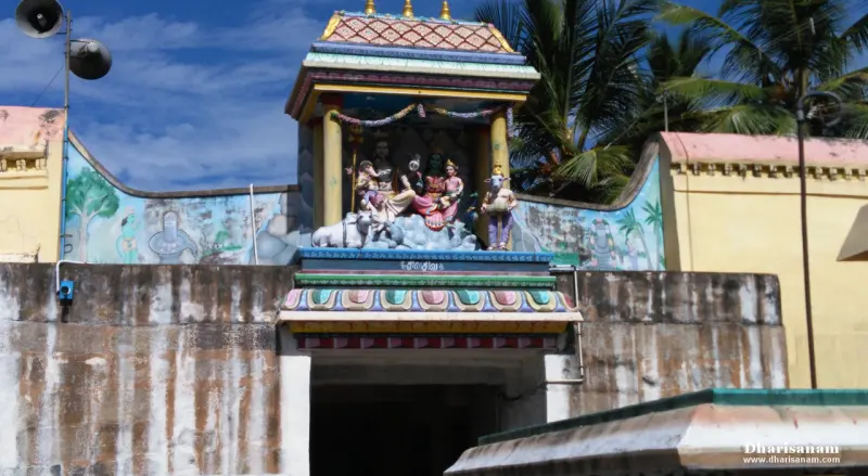 A painted tower over a gateway showing Lord Shiva and Goddess Parvathy with Vinayakar, and a bull beside them
