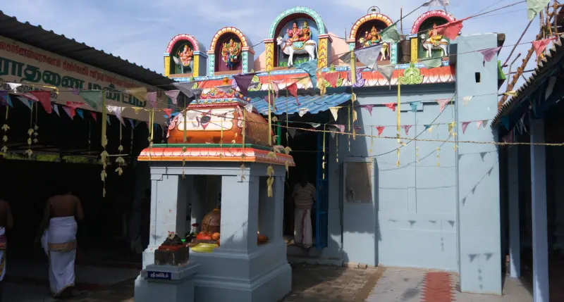 Small shrine before a wall of deity niches hung with buntings