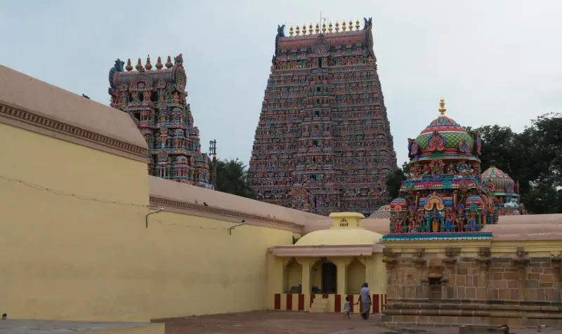 Two tall gopurams and a small shrine in a walled yard