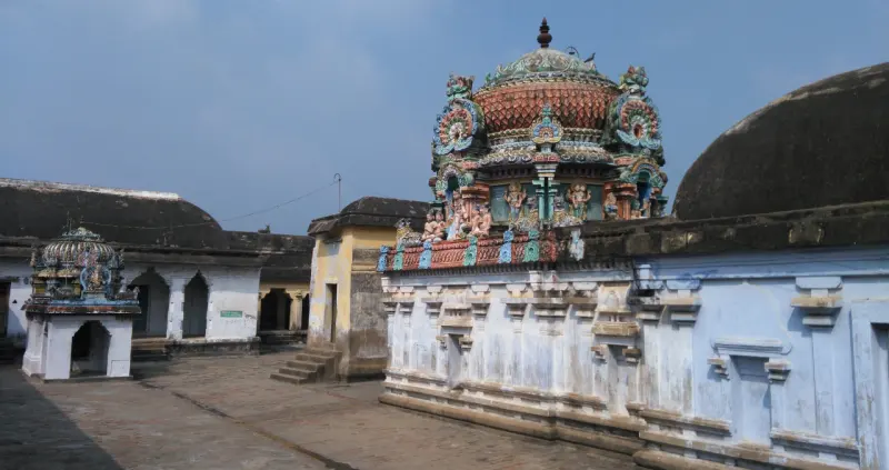 Painted stucco tower with figures above white shrine walls