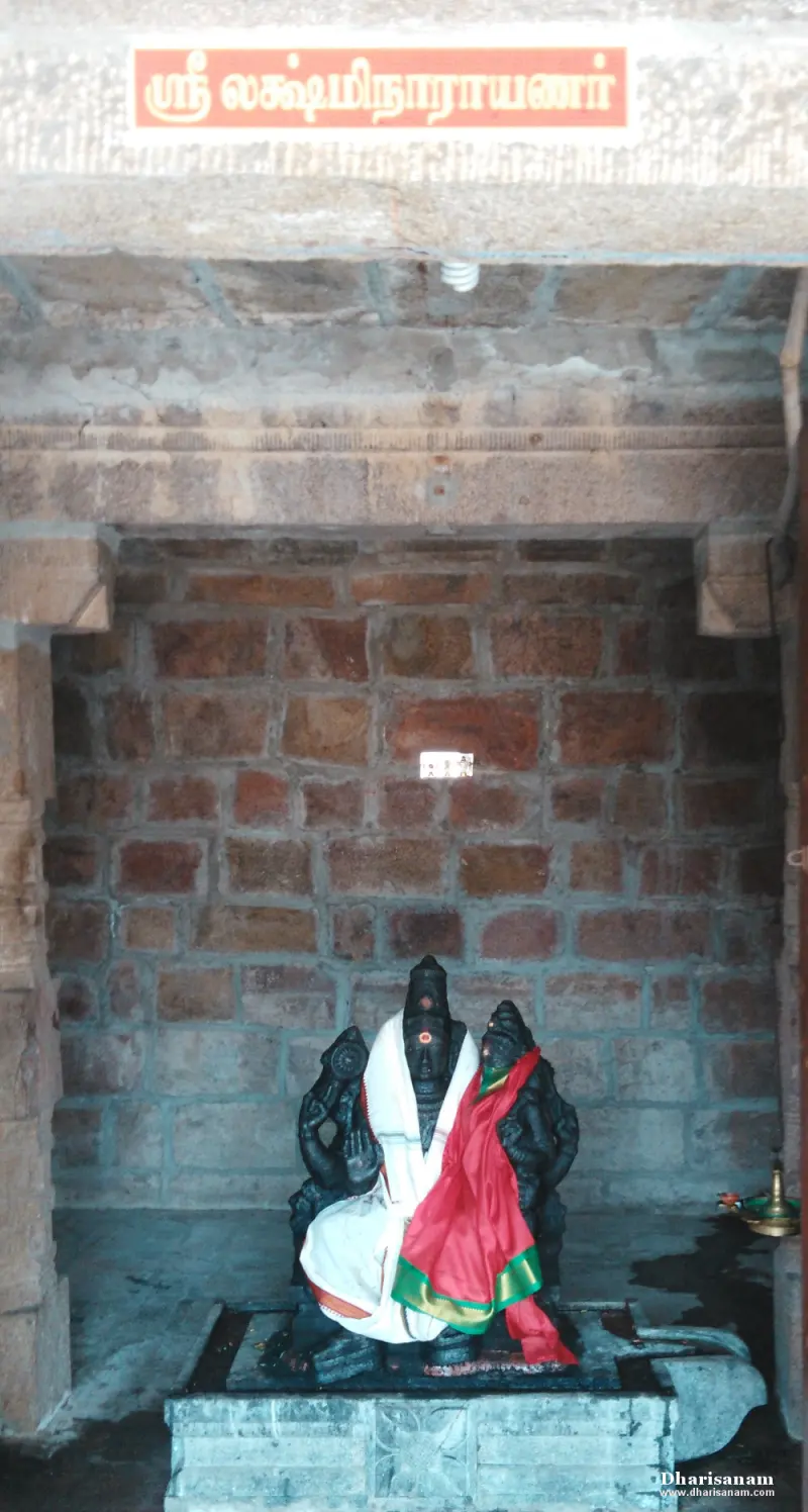 Lakshmi seated on Narayanar's lap in a brick shrine with name board