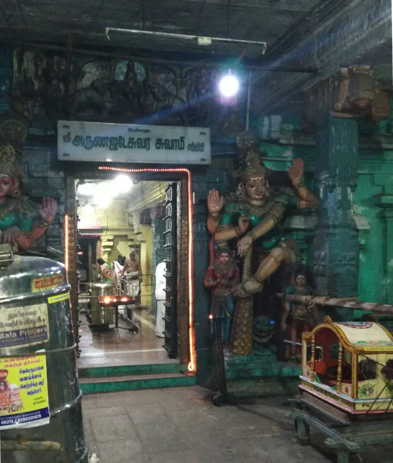 Lit doorway with a name board and guardian statues