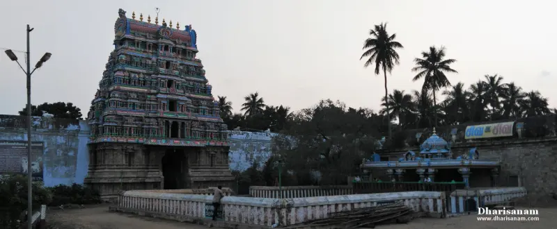A tiered gopuram at left and a small shrine on a raised platform at right, among palm trees