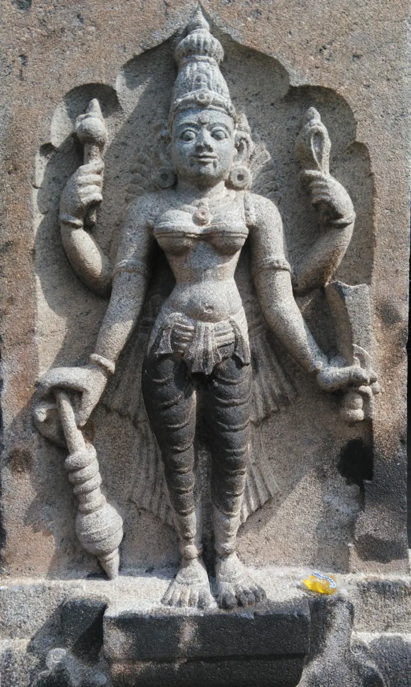 Close view of a four-armed goddess with mace and conch