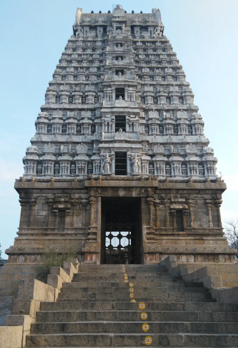 A flight of broad stone steps rising to a tiered gopuram with a dark doorway