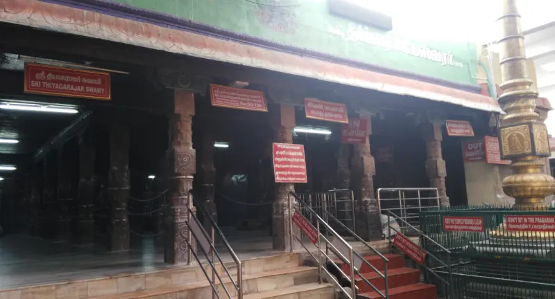 A pillared mandapam with steps and a golden flagstaff