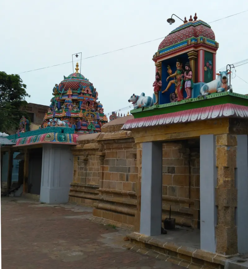 Carved stone doorway topped by painted gods and Nandis