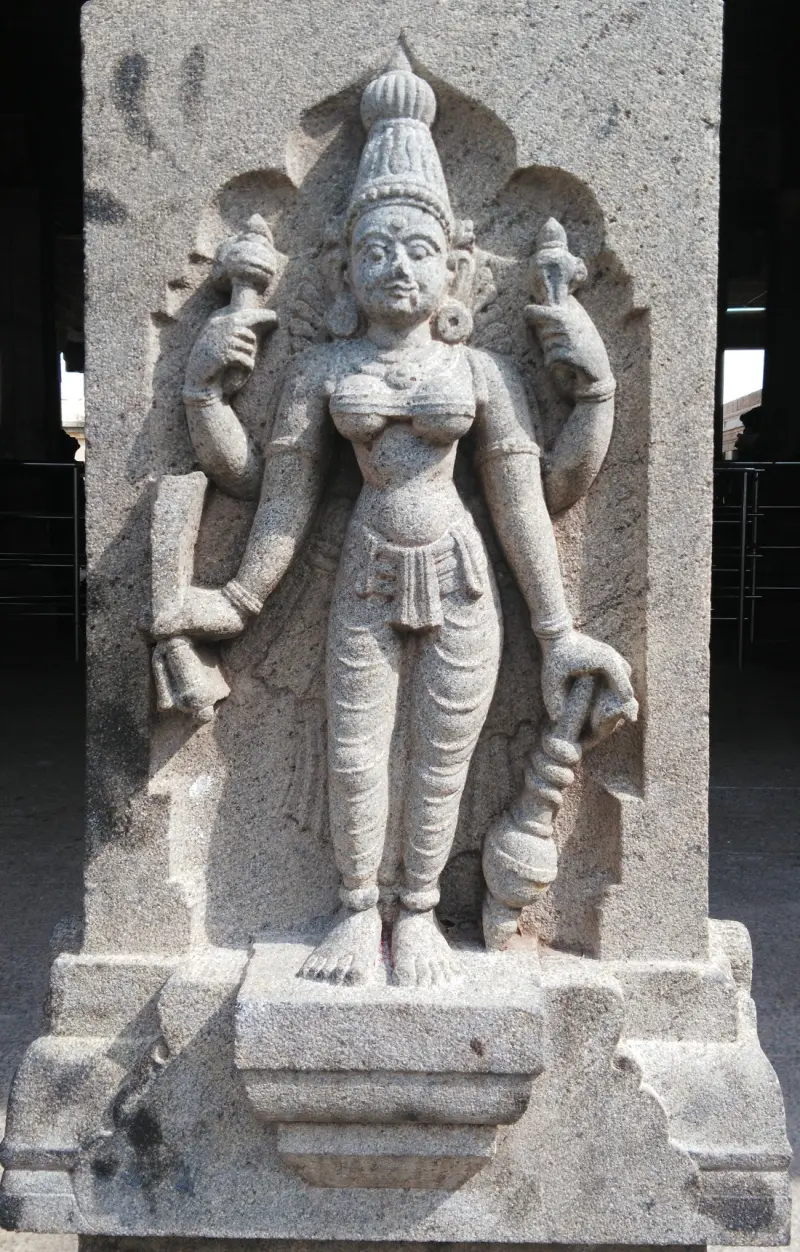 Four-armed goddess holding conch and disc on a pillar