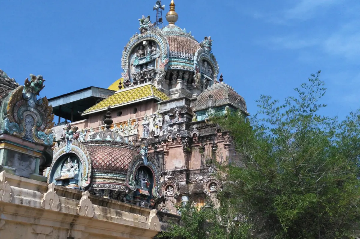Painted stucco towers and domed roofs of the temple rising against a blue sky