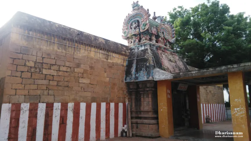Sculpted tower above a stone wall painted with red and white stripes