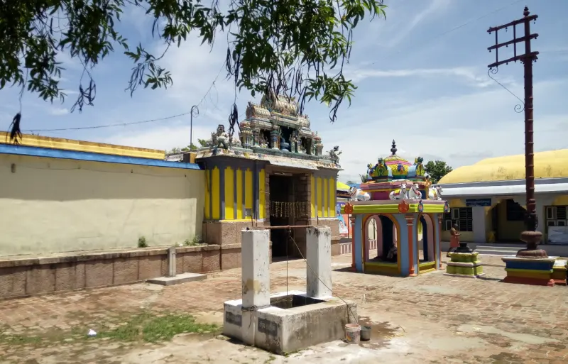 Paved courtyard with a stone platform, a pillared hall with a tower, and a small painted shrine