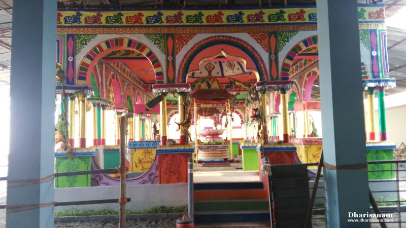 A brightly painted open pavilion with arches and a small shrine at the centre