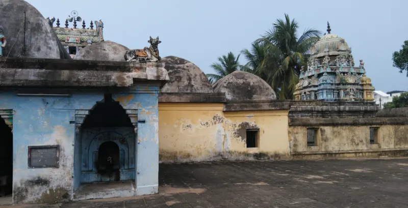 A small blue-painted shrine in the courtyard, tower behind