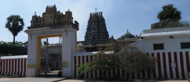 Entrance gate with striped walls and the sculpted tower behind