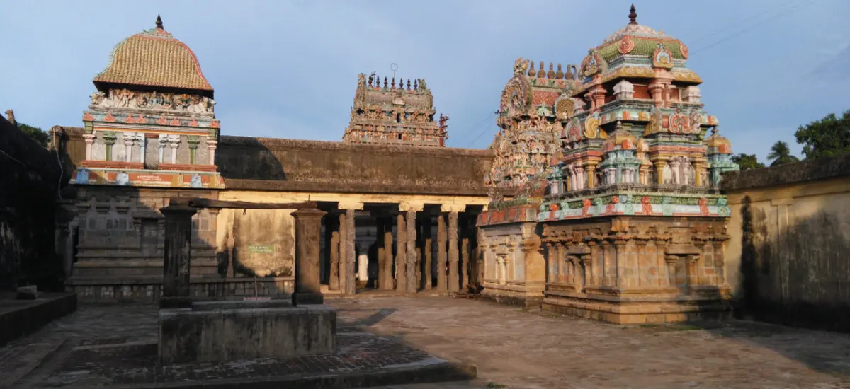 Stone courtyard with sculpted shrine towers and a pillared hall