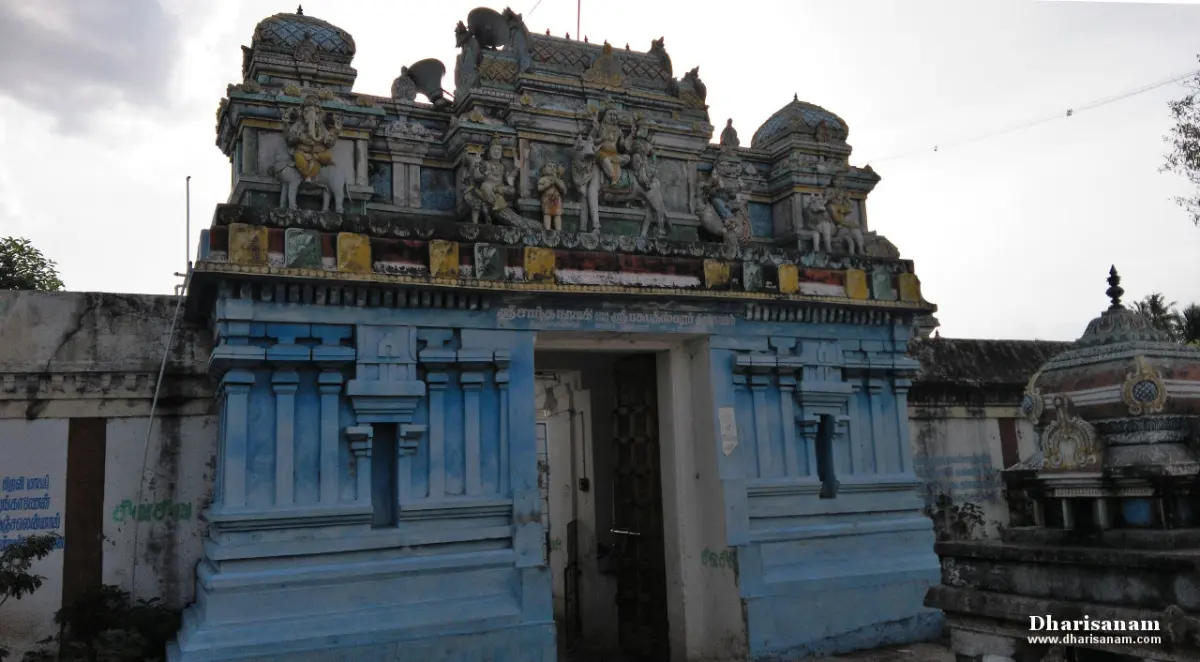 Blue entrance tower topped with painted sculptures, with a doorway below.