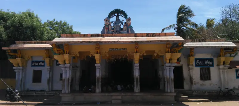 A pillared hall with a sculpted crest above the entrance