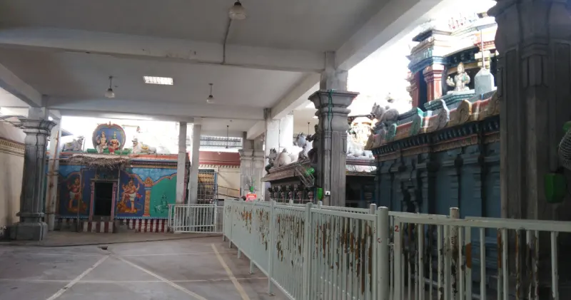 A covered walkway beside a painted shrine