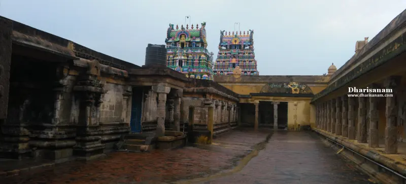 Wet stone corridors on both sides, with two painted towers rising at the far end