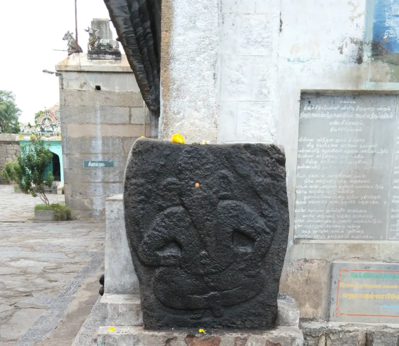 A black stone slab carved with a seated Vinayakar by the entrance