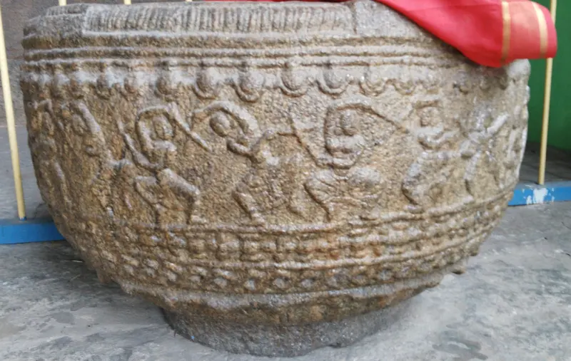A round stone bowl with a band of dancing figures carved around its side