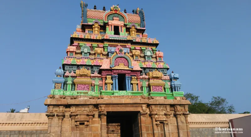 Brightly painted tower rising in tiers above a stone base, against a clear blue sky