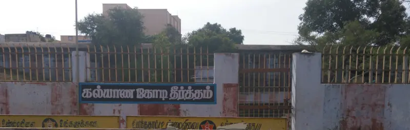 Fenced gate with a Tamil board naming the Kalyana Kodi Theertham