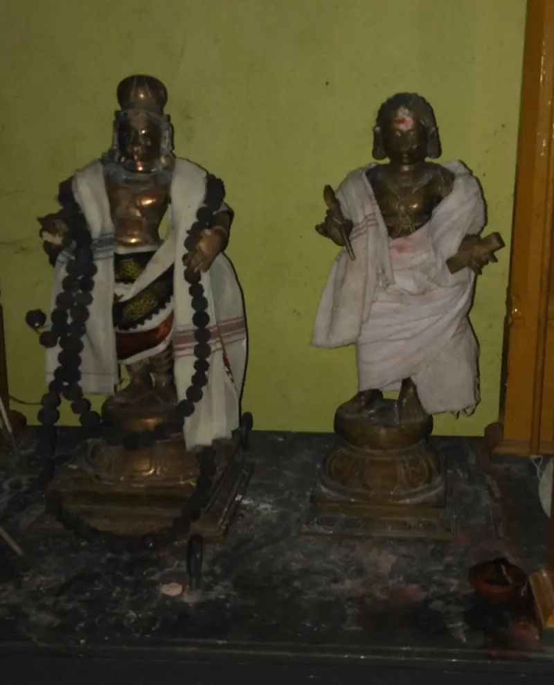 Two bronze idols, one holding a stylus and palm leaf