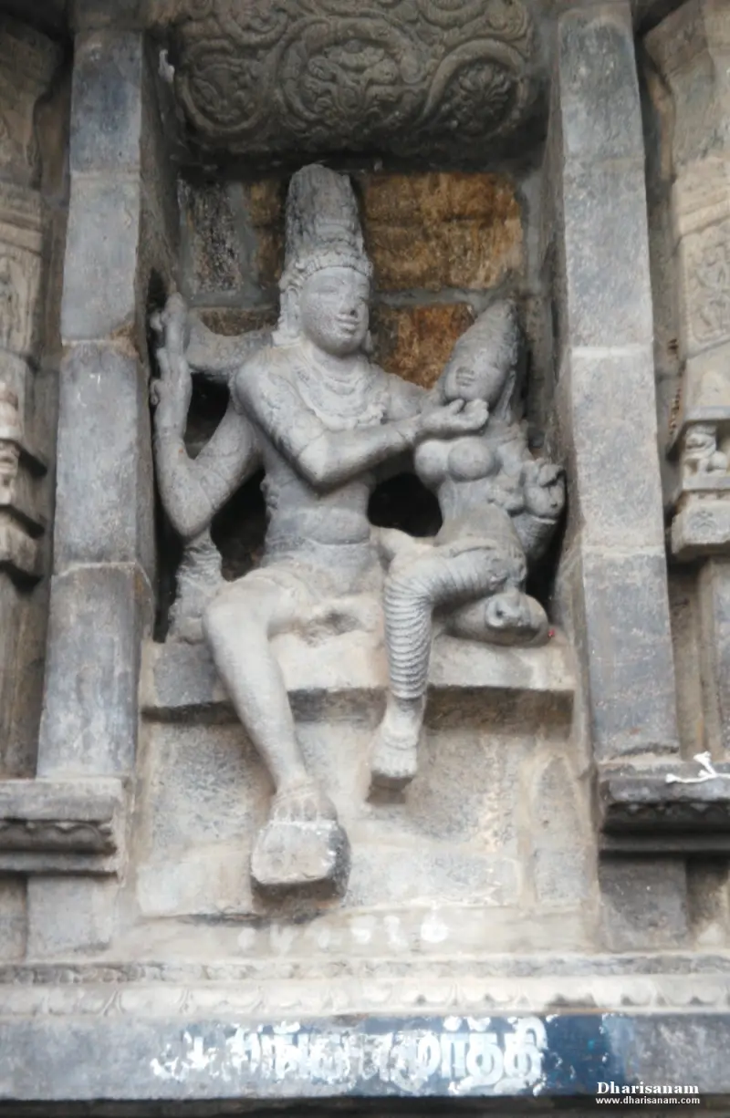 A relief carved in a wall niche: a crowned male figure seated with a goddess beside him.