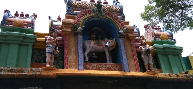 A painted niche with seated figures on a white bull, flanked by a standing figure on each side.